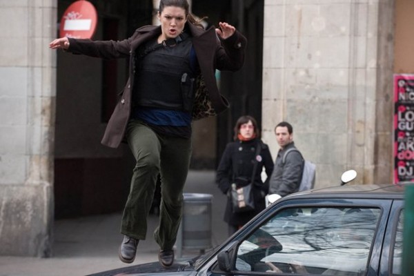 Gina Carano as Mallory leaping over a car