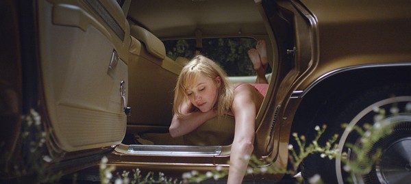 Jay (Maika Monroe) waits for her boyfriend in her car